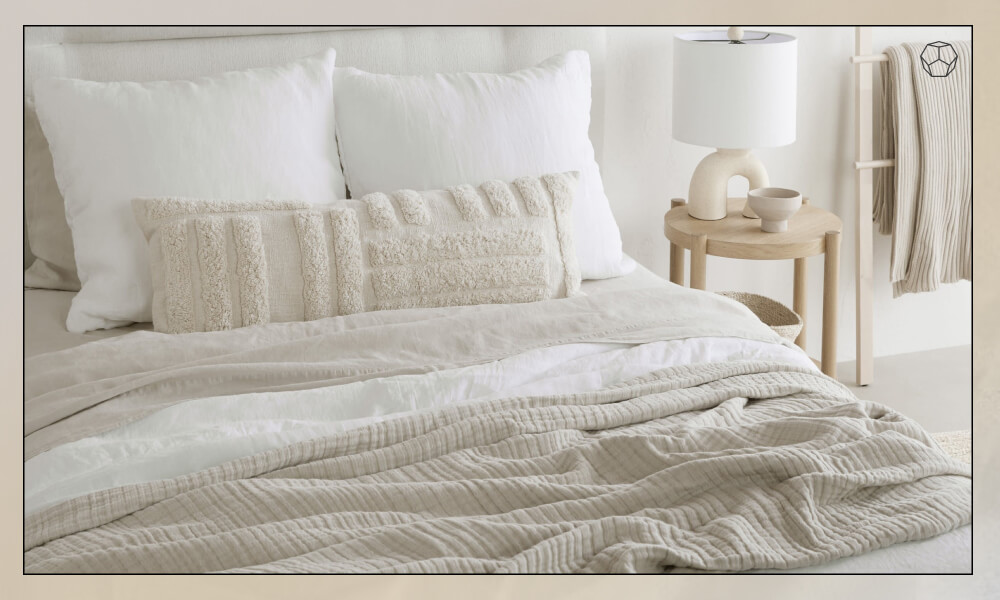 A set of white and beige pillows in a bed