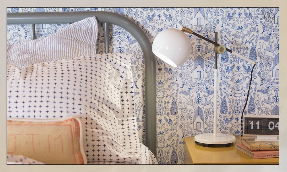 Table Lamp in a nightstand in one side of a bed with an aluminum headboard and three pillows