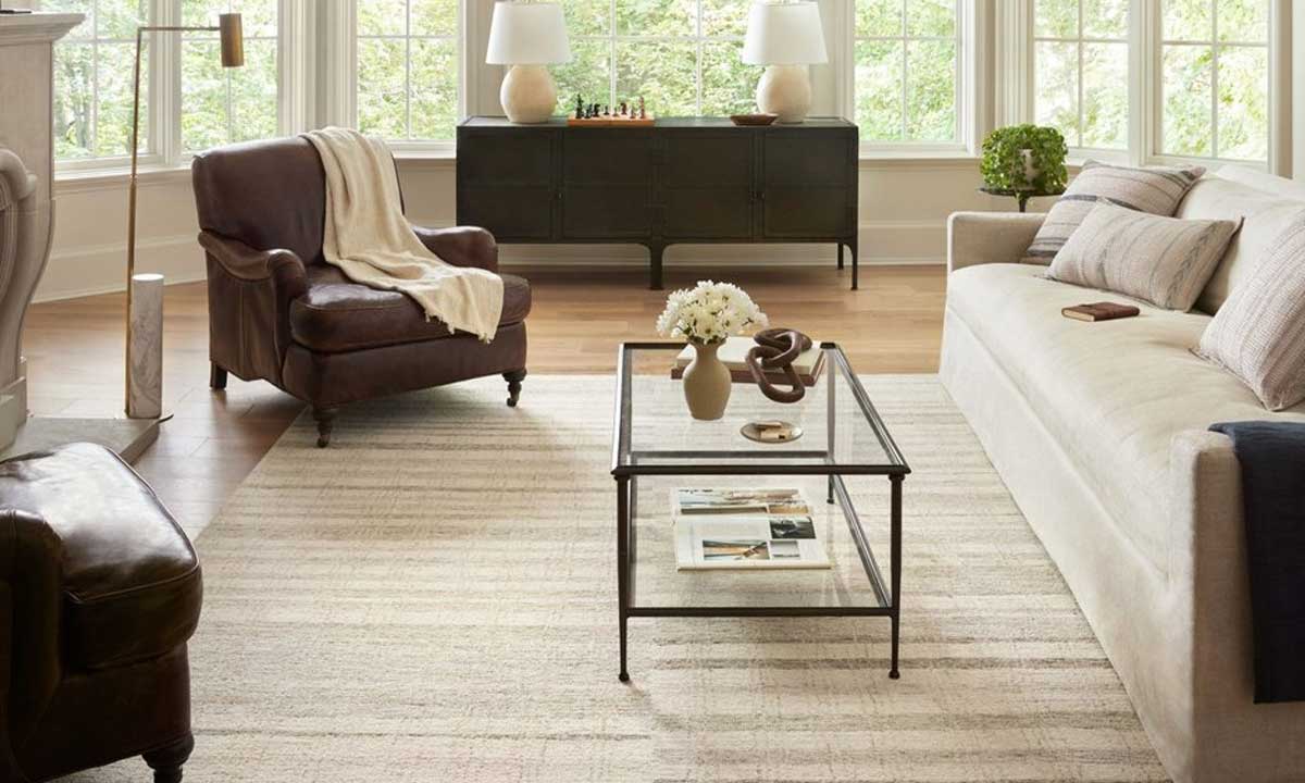 Grey rug with beige textures in a living room with a black aluminum frame coffee table and a sofa
