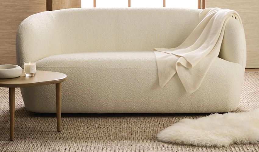 white upholstered sofa with a subtle curved design and a low profile