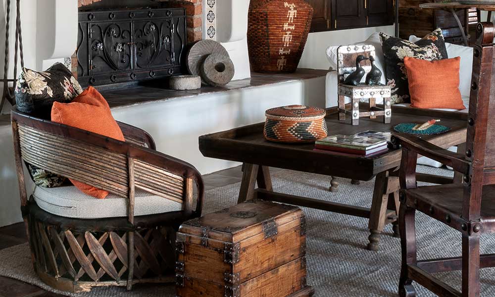 Living room with a fireplace, wooden furniture, coffee table and bright orange pillows