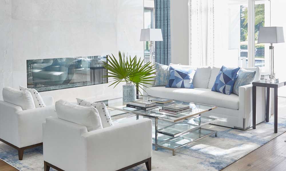 modern living room with white furniture, accent chairs and a glass coffee table with books