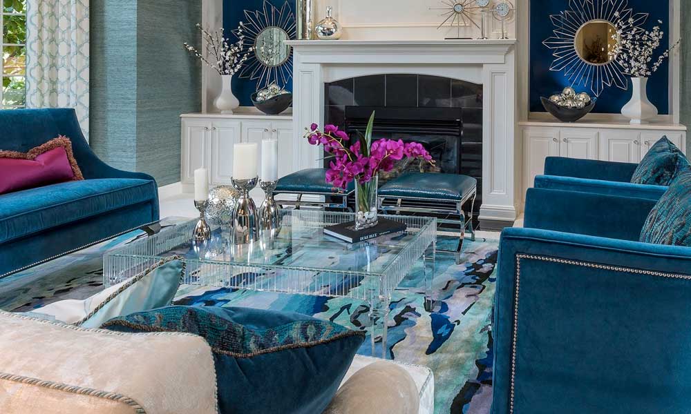 A living room with blue couches, a fireplace, and a bouquet adding a touch of elegance