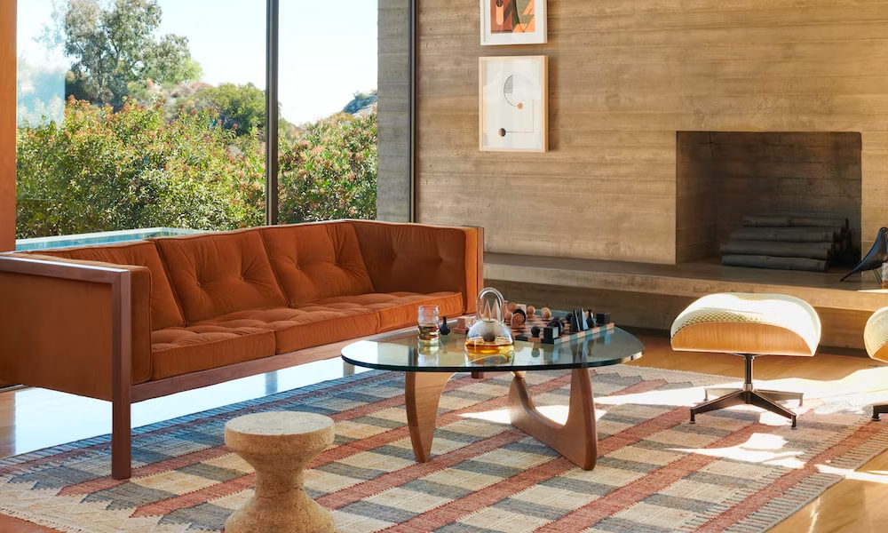 Modern living room with a brown sofa, a noguchi coffee table and a ottoman