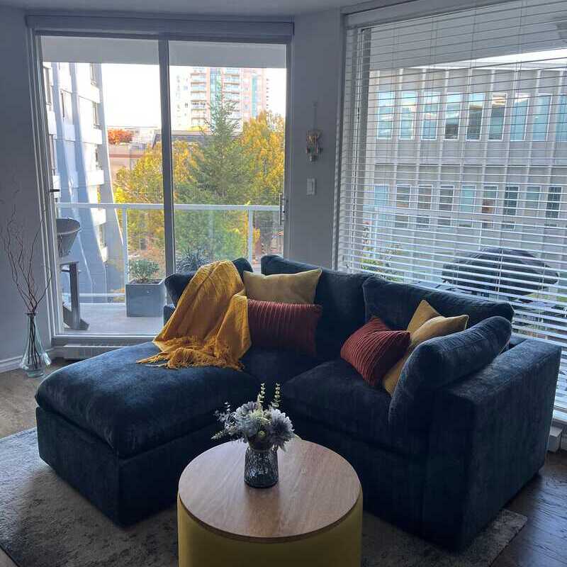 White L-sectional couch in a living room with natural light and neutral color palette.