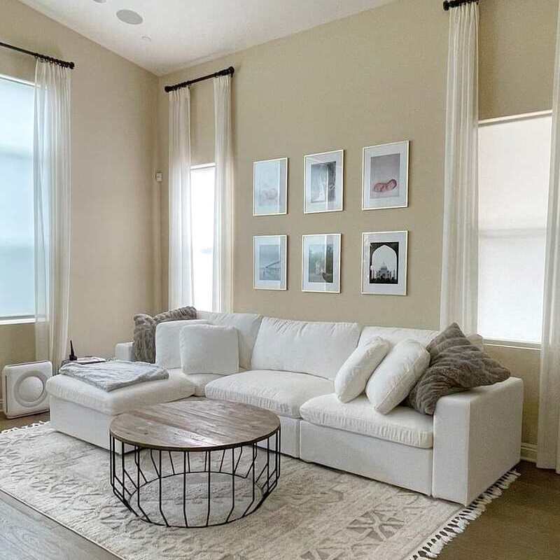 White modular sofa placed in front of a bookshelf. 