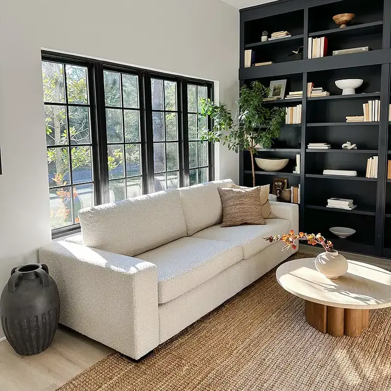 Sand white sofa in a living room with pillow and throw blanket