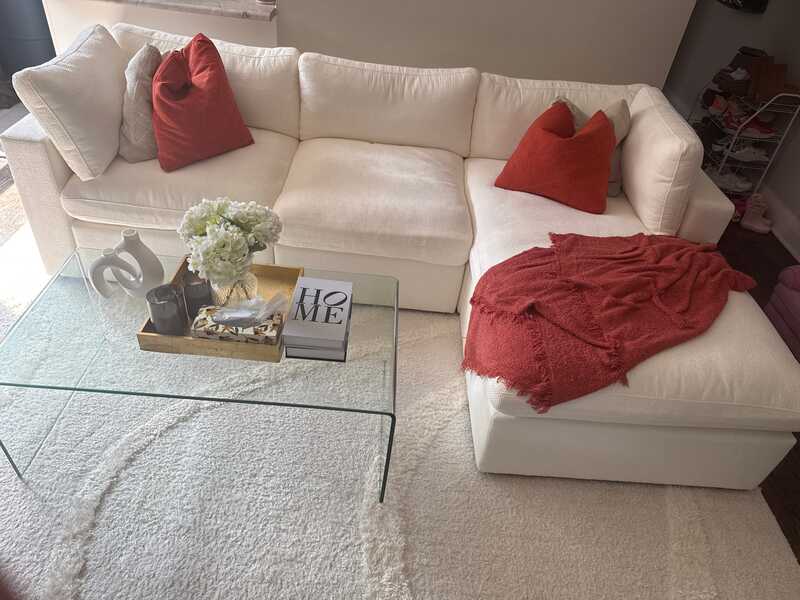 White L-sectional couch in a living room with natural light and neutral color palette.