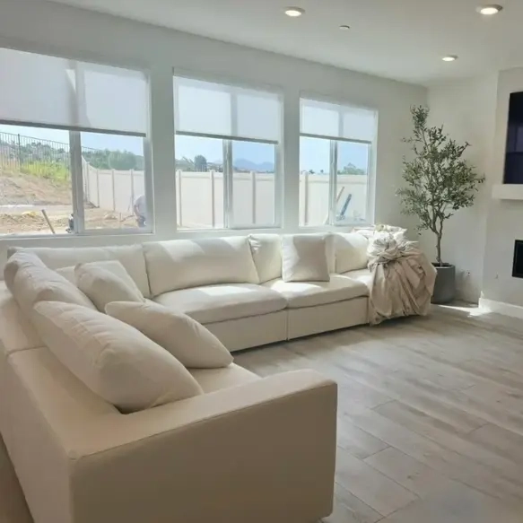 White modular sofa placed in front of a bookshelf. 