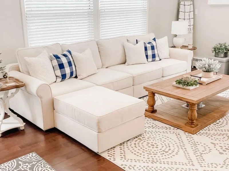 White sectional sofa with white throw pillows and 