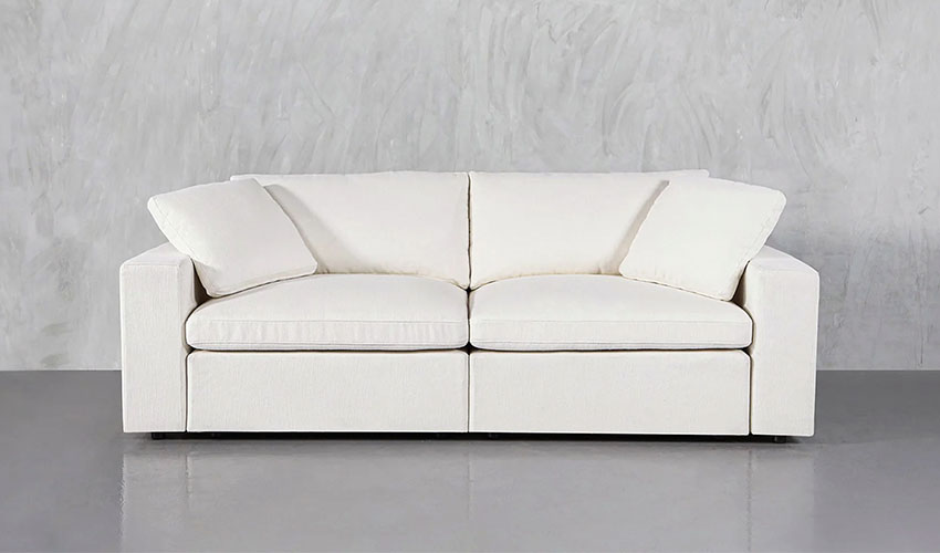 White upholstered loveseat with pillows