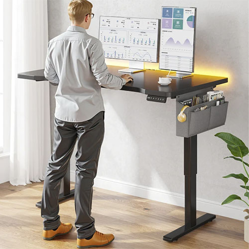 A man works on a standing desk