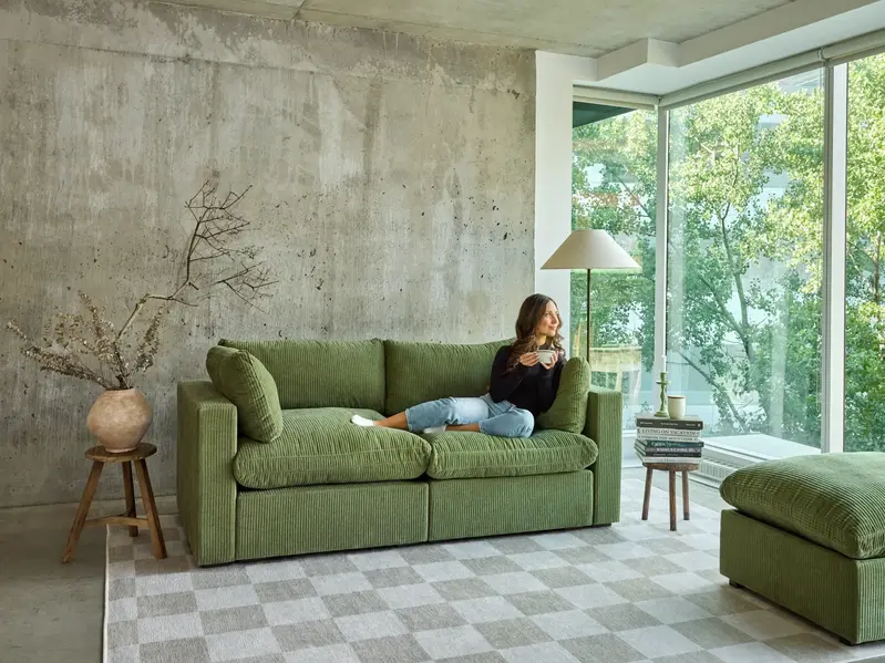 Woman with coffee on 2-seater sofa
