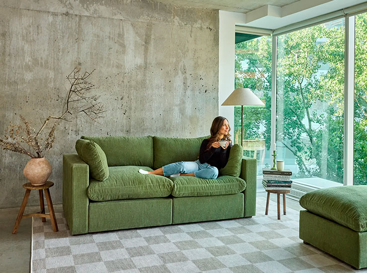 Green Modular Sofa in a bright living room with a light gray rug and a rounded side table