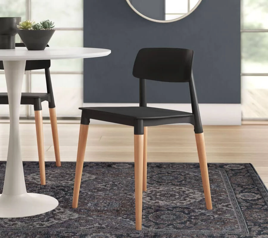 Black Dining Chair with natural wooden legs placed near a rounded white table