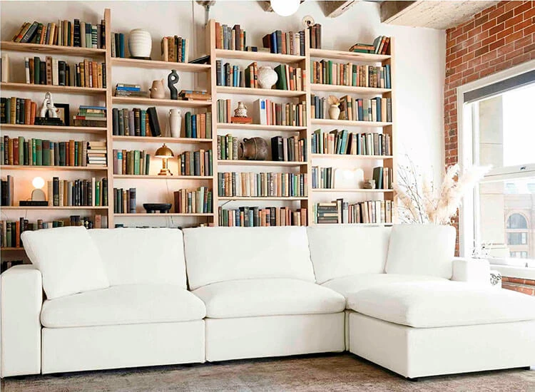 White four pieces sectional sofa with a large book shelf behind it