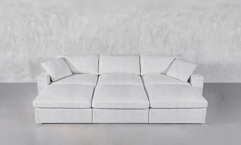 6-piece light grey upholstered pit sectional sofa with two large throw pillows