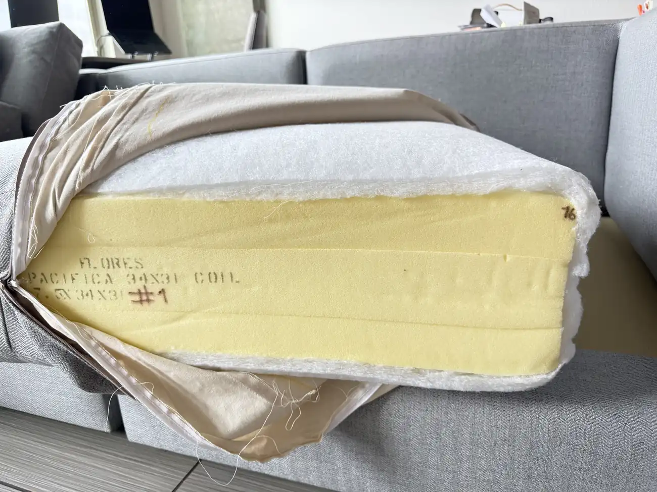 Unzipped Landon seat cushion showing the yellow foam core stamped with coil unit markings