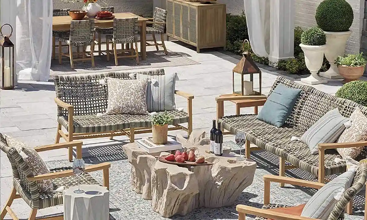 Outdoor patio set with a mix of white and grey wicker and wooden materials with plush cushions