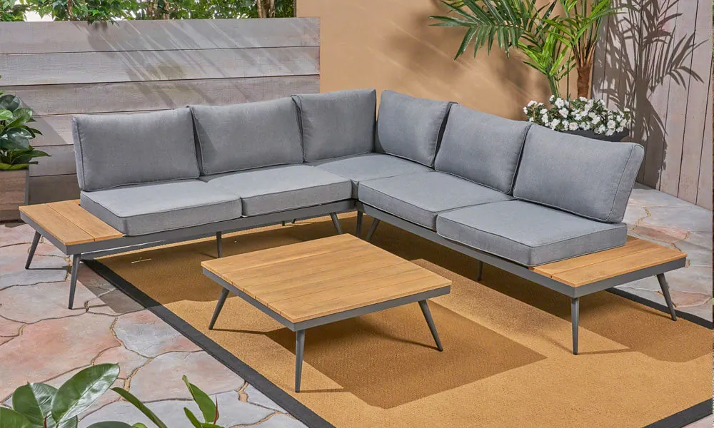 Modern 4 Piece Sectional Seating set with grey cushions in a patio near plants