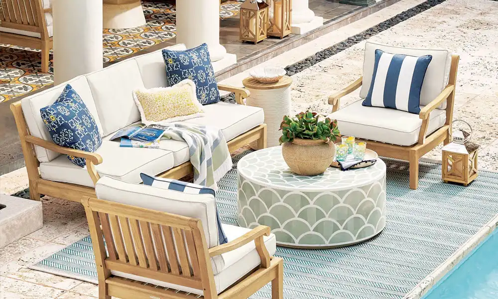 Outdoor furniture set with blue and white striped pillows, perfect for relaxing in the sun.