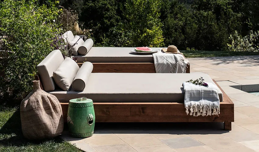 Wooden outdoor daybed with gray cushions and pillows