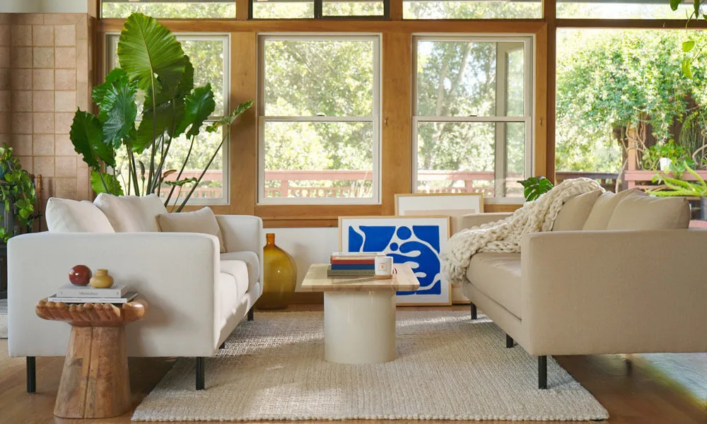 Living room with two sofas, one is white and the other one is light brown both with black legs