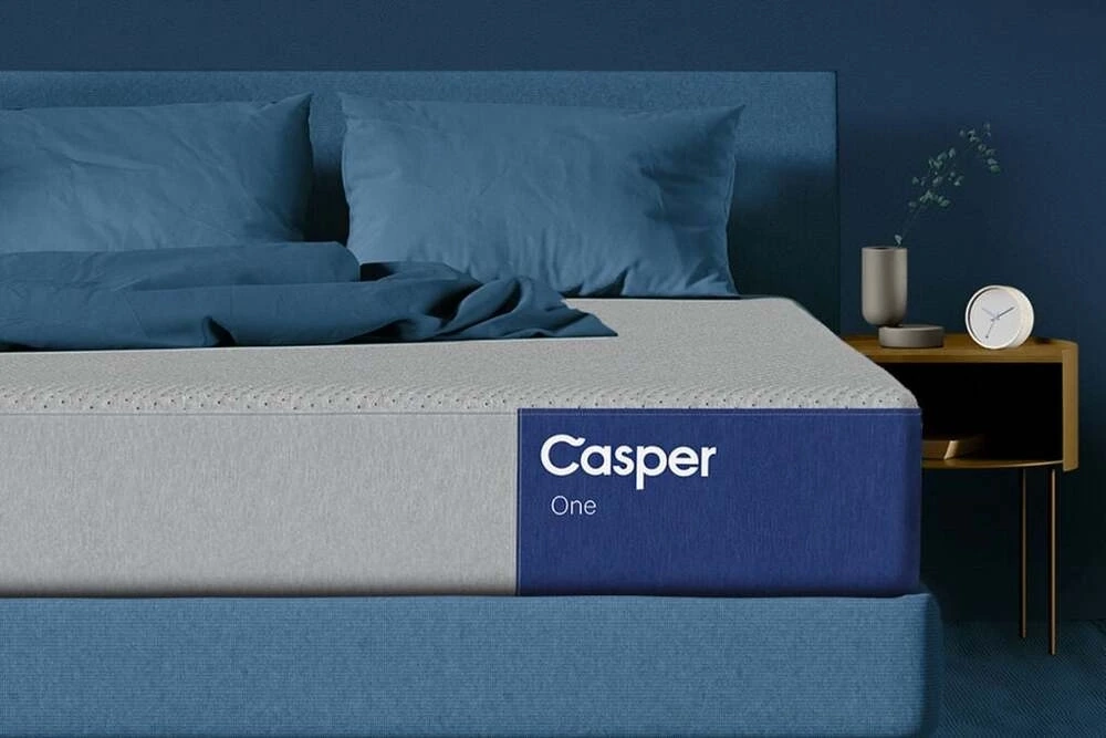 Memory foam mattress from casper in a bedroom with clue pillows and sheets