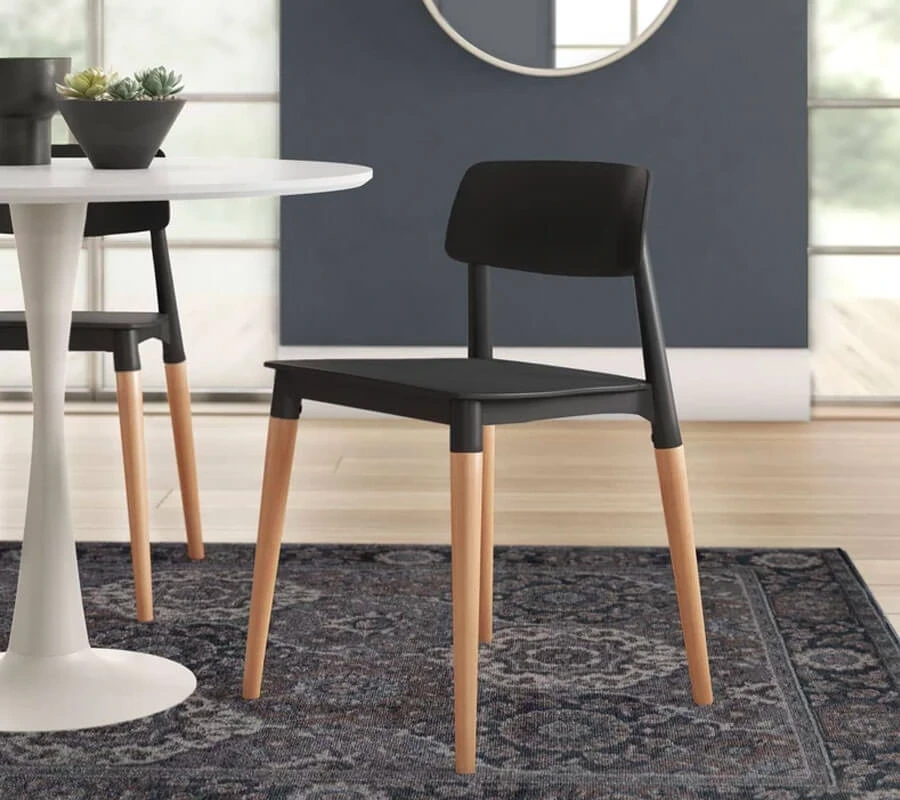 Black Dining Chair with natural wooden legs placed near a rounded white table