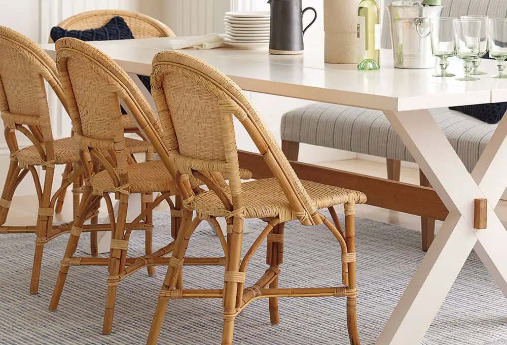 Rattan dining chairs arranged with a white dining table in a living room