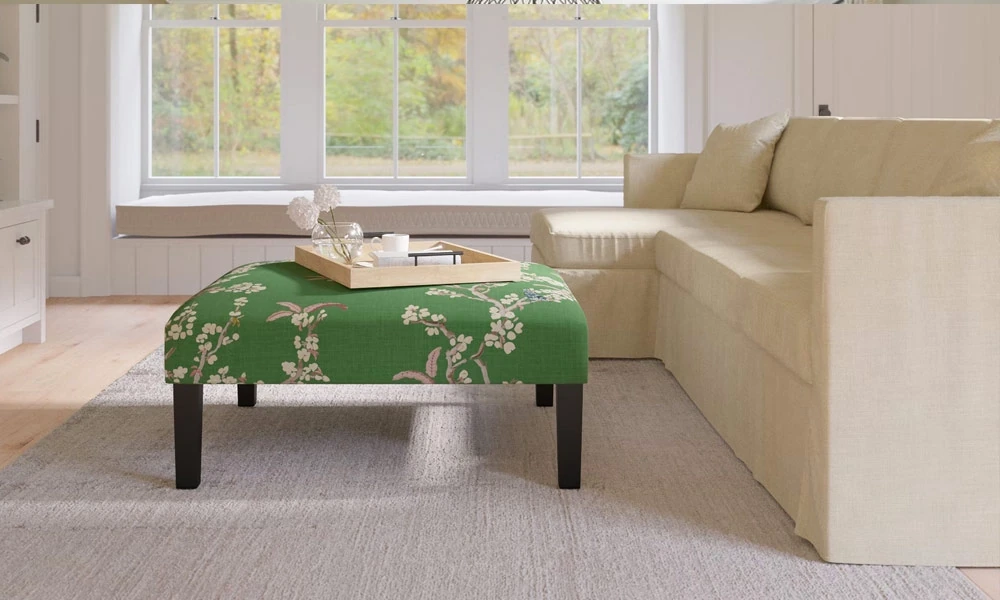 Green upholstered Ottoman Coffee Table in front of a beige sofa in a living room