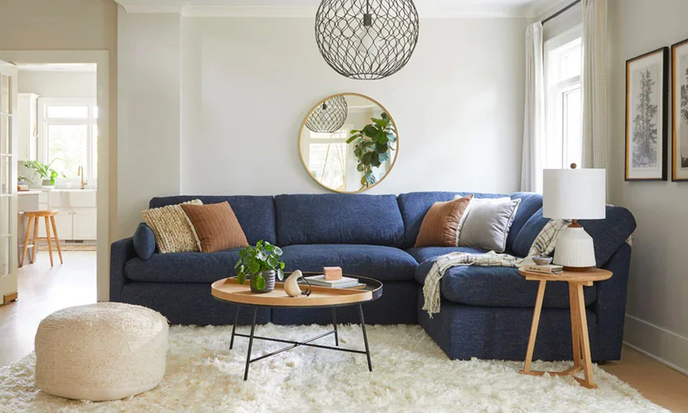 Wooden round Coffee Table in a white rug in front of a blue sofa in a cozy living room