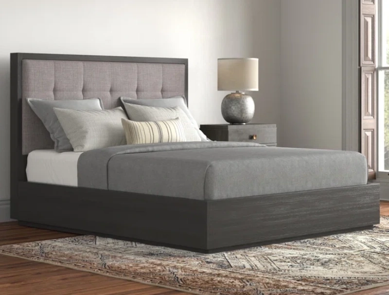Grey platform bed with storage, a headboard with light gray cushion and a mattress with grey bedwear