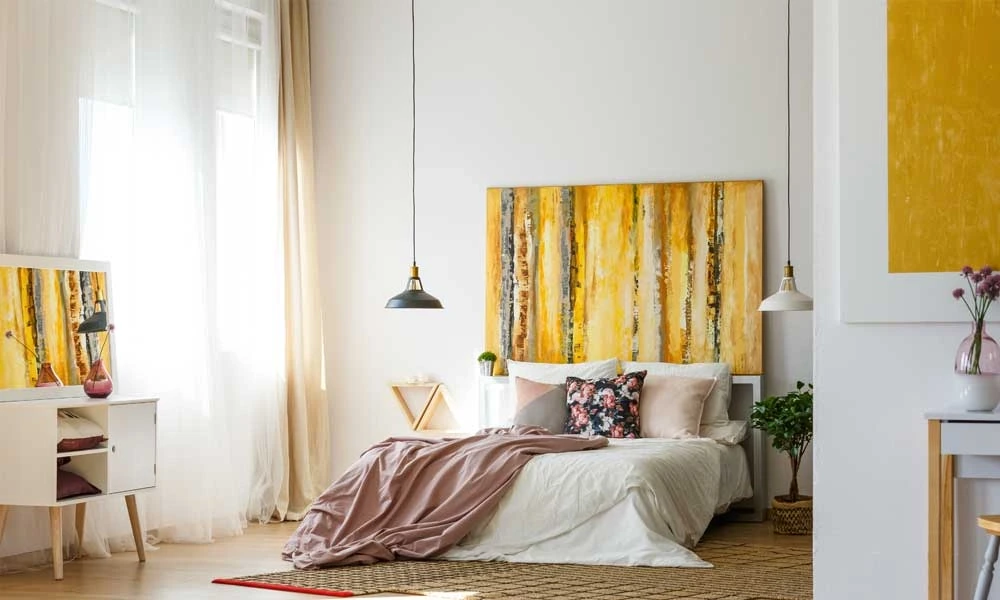 A stylish bedroom with a large yellow artwork in white wall