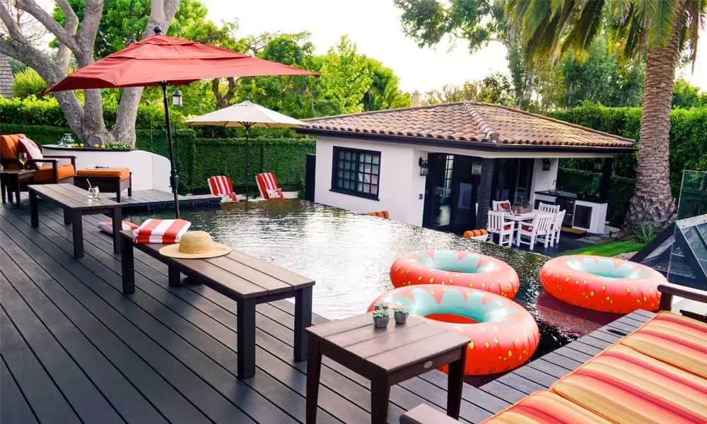 Backyard setting with a pool, lounge chairs, and umbrellas for relaxation
