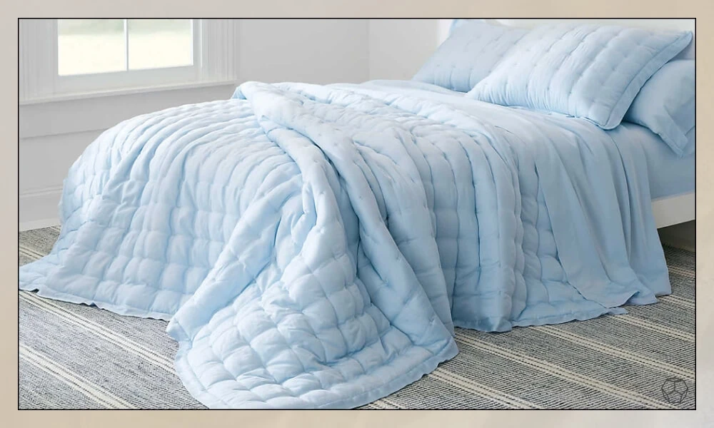 Blue Woven Wool Rug under a bed with a light blue duvet and matching cozy pillows