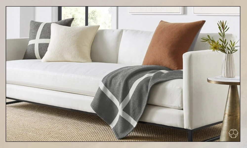Grey throw blanket in a white sofa in a living room