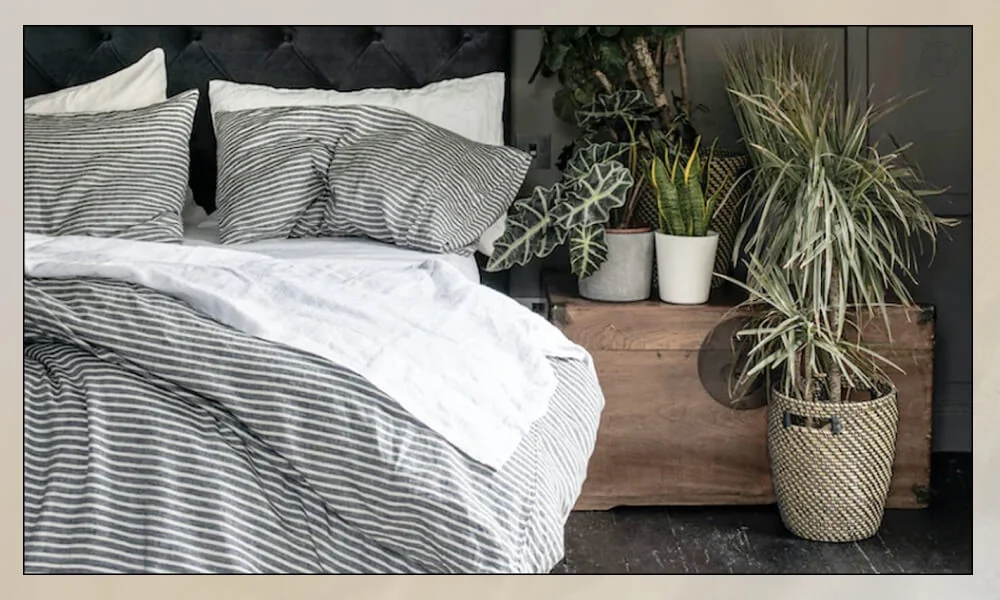 Dark grey and white striped comforter with white sheets and matching pillow covers