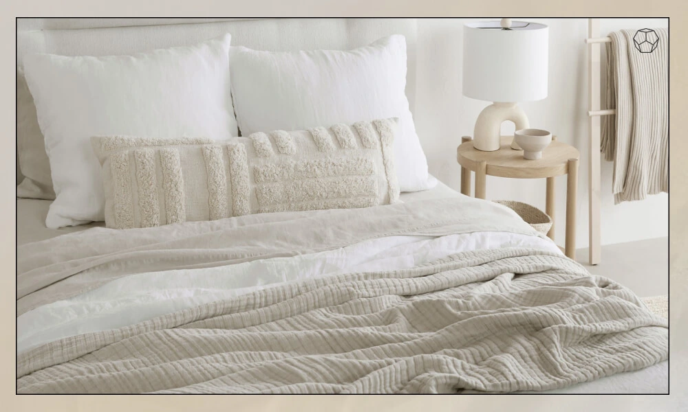 A set of white and beige pillows in a bed
