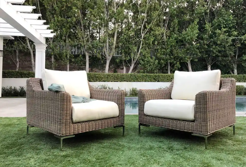 Outdoor seating with two wicker chairs on a lush green lawn