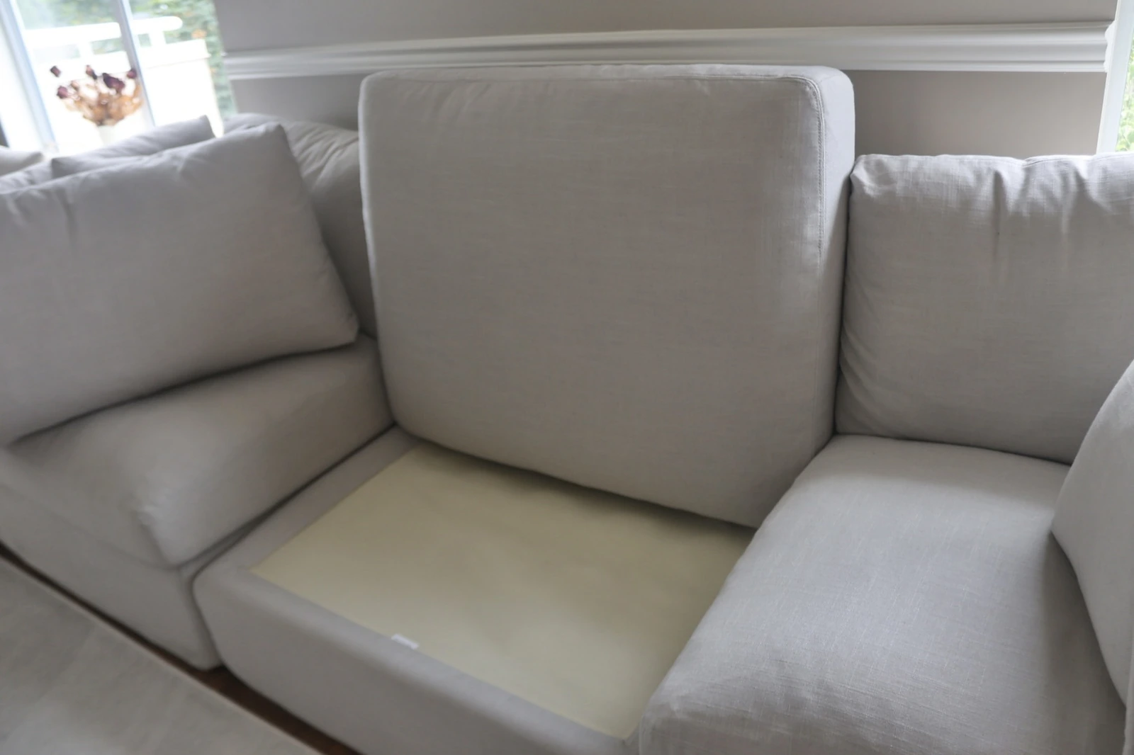 A seat cushion lifted off the Sundays Get Together sofa, showing the foam core and deck underneath