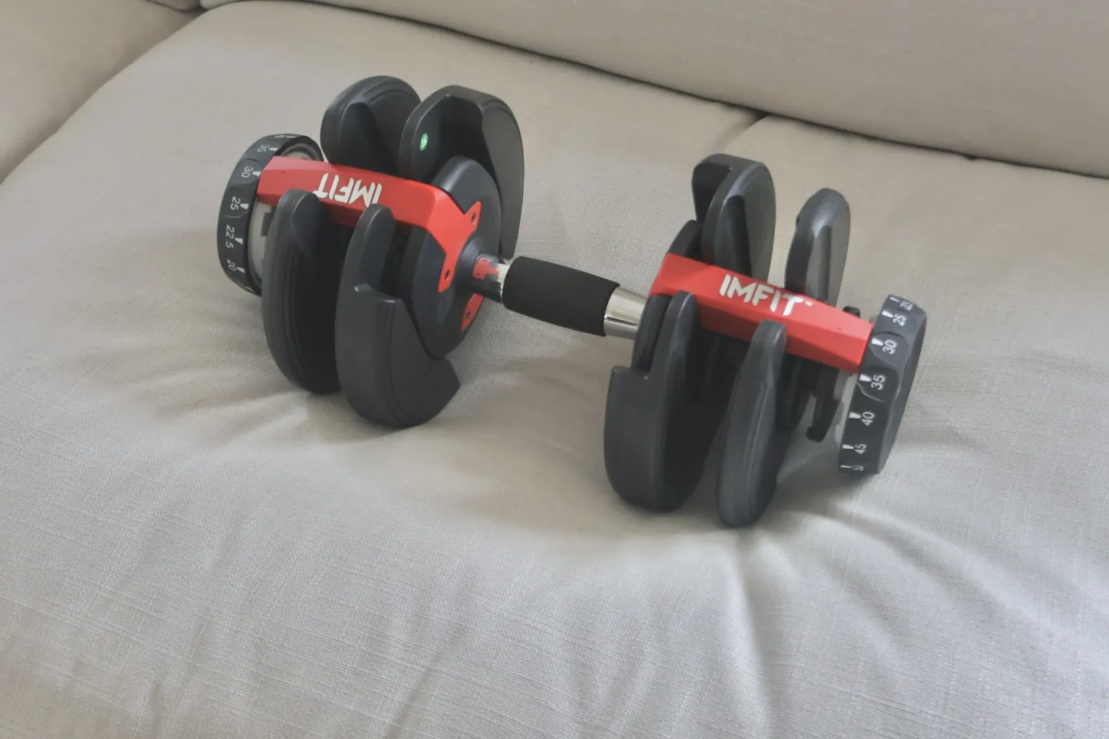 An adjustable dumbbell resting on a seat cushion of the Sundays Get Together sofa, showing how little the cushion compresses