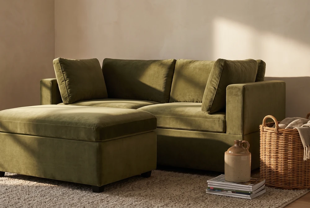 Albany Park Kova sofa and ottoman in olive velvet in a warm living room