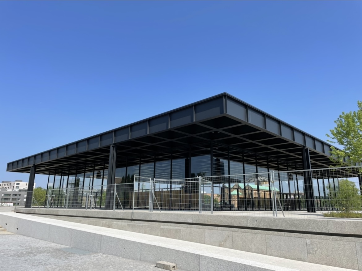 Neue Nationalgalerie in Berlin, modernist glass and steel museum designed by Mies van der Rohe, photographed on a clear blue sky day.