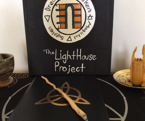 Wood box/table with beeswax candle, jar of incense, alter cloth, and other items.