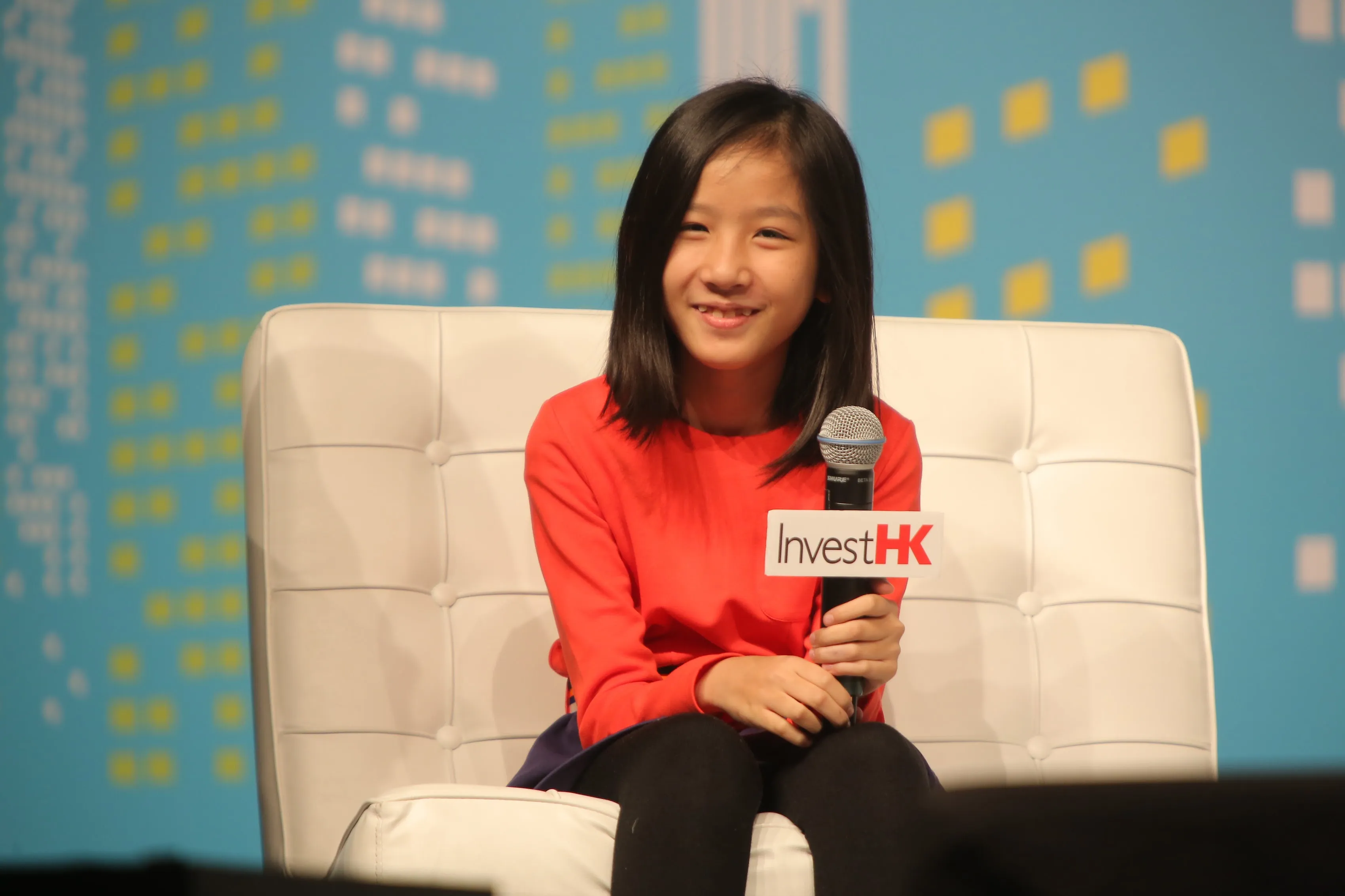 12 year old CEO Hillary Yip sitting on stage at Invest HK