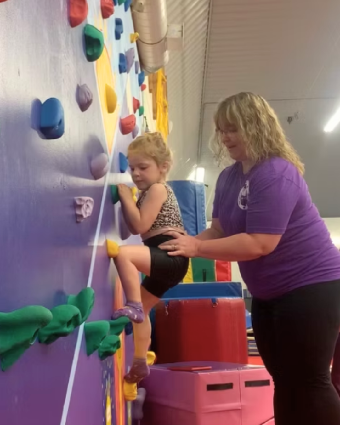A mom helping a child climb a ladder