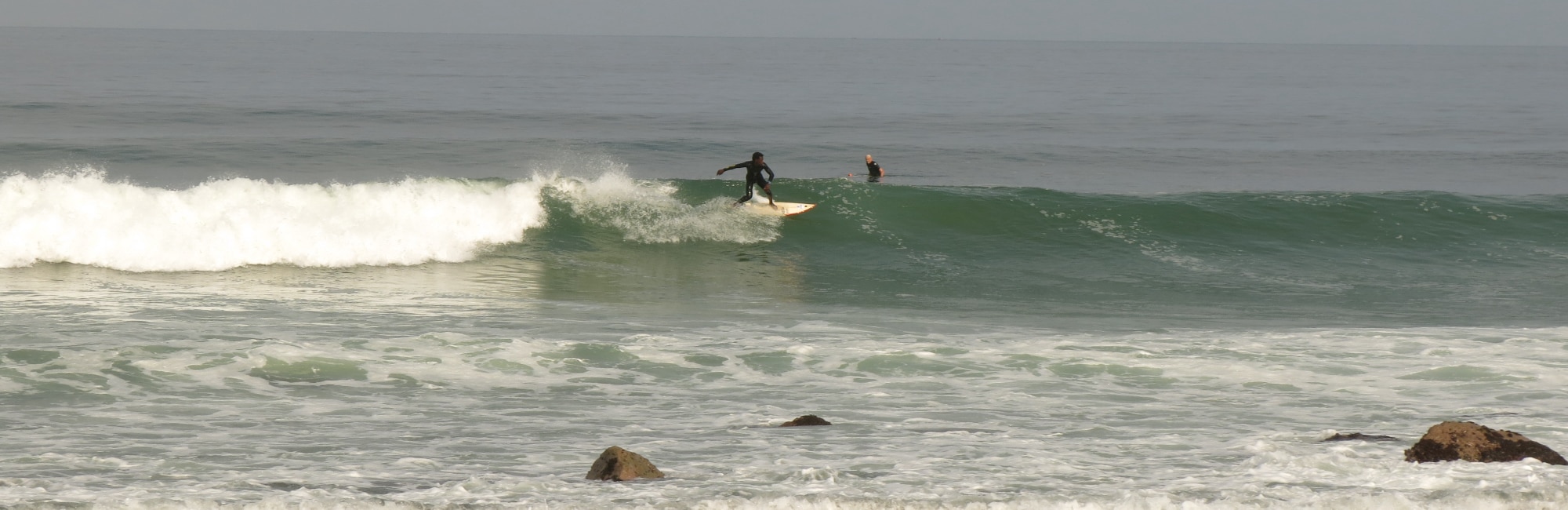 local surfer riding a long wave in angola