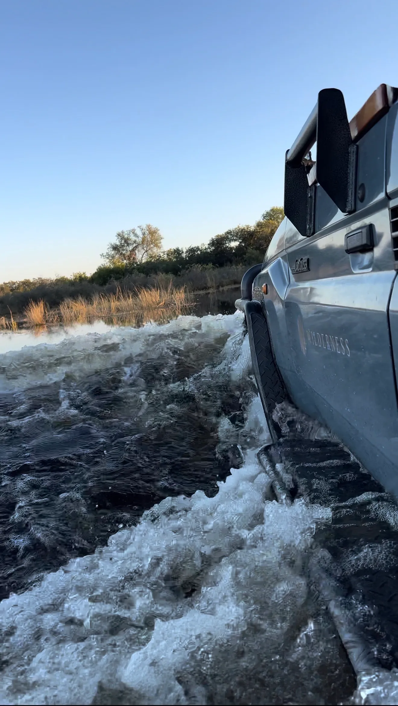 a gameviewer driving through the Delta flood waters