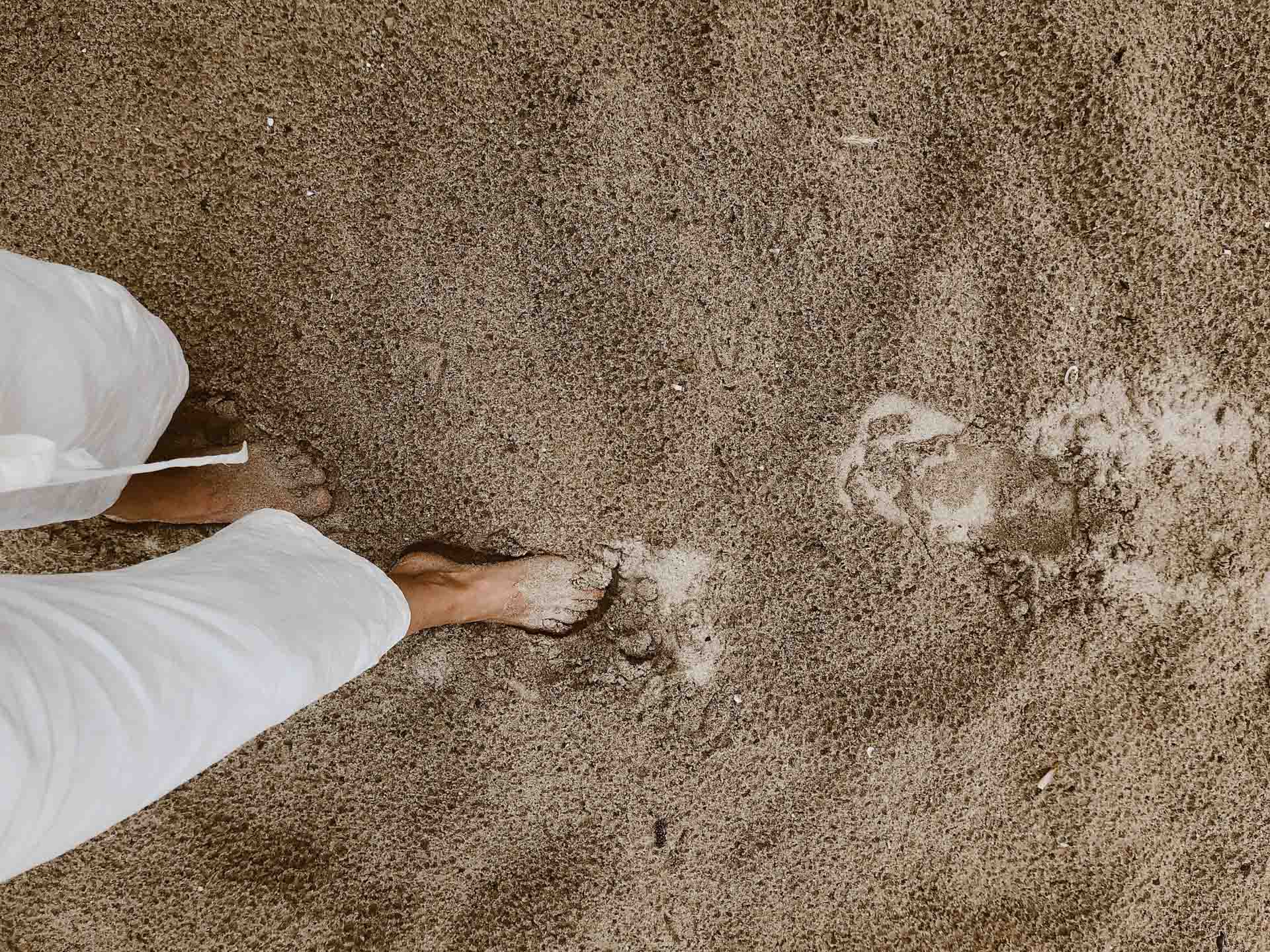 top down view of woman walking through wet sand
